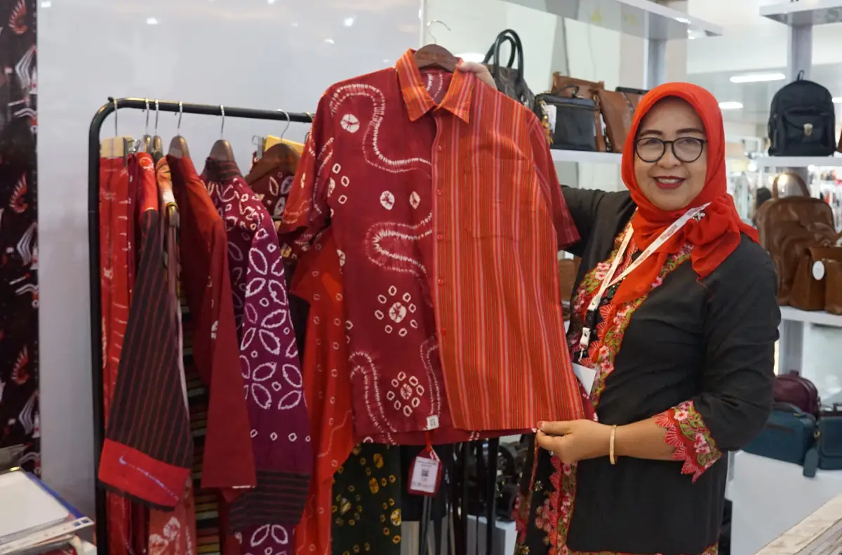 Tuliswati menunjukan baju yang dikreasikan kain jumputan dan lurik. (Sumber: istimewa)